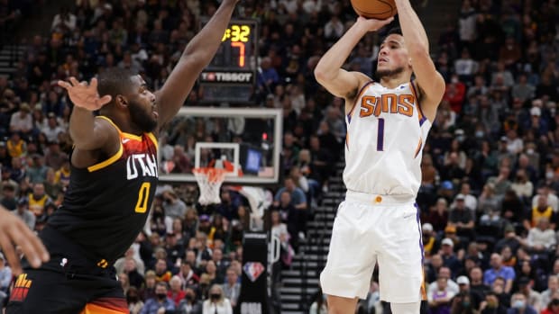 Jan 26, 2022; Salt Lake City, Utah, USA; Phoenix Suns guard Devin Booker (1) shoots the ball over Utah Jazz forward Eric Paschall (0) during the third quarter at Vivint Arena. Phoenix Suns won 105-97. Mandatory Credit: Chris Nicoll-USA TODAY Sports